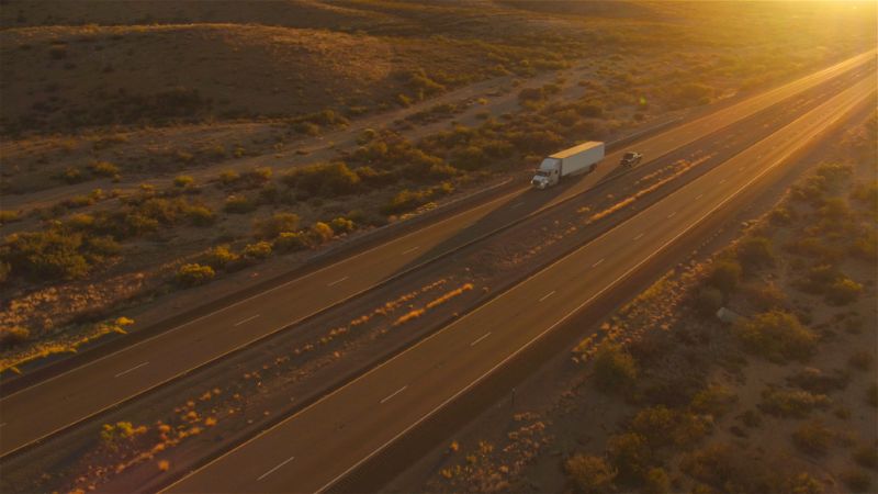 Aerial view of a semi-truck on the highway at sunset