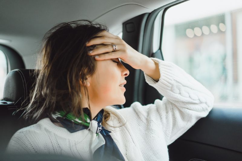 Woman stressed in the back seat of a car