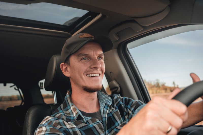 Man driving a truck with a smile on his face